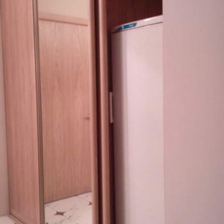 Двери-купе с наполнением из ДСП и зеркала в гардеробной в квартире в Ольгино.