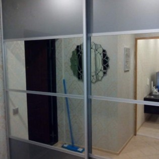 Двери-купе с наполнением из зеркала и декоративного стекла с разделителем в квартире на ул. Дудина