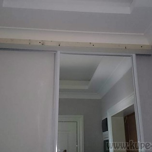 Зеркальная дверь-купе в ванную комнату в квартире на Ждановской наб. д.27. Профиль - белый глянец. Виден способ крепления верхней направляющей.