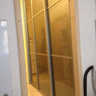 Двери-купе с наполнением из декоративного стекла (тонировка плёнкой Oracal) и разделителями в квартире на 13 линии В.О.